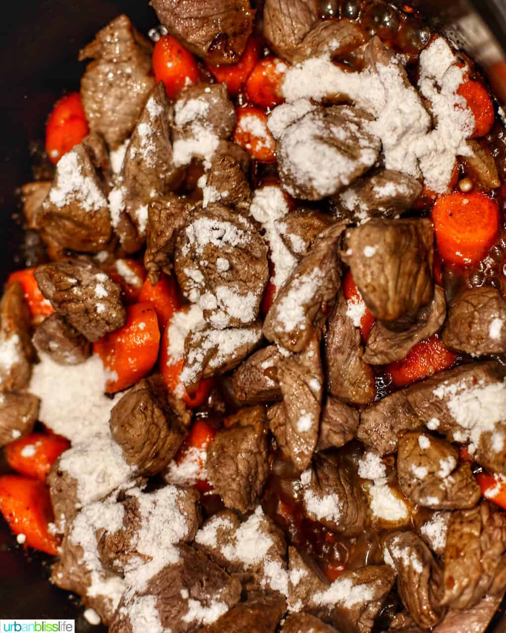 adding flour to beef and carrots