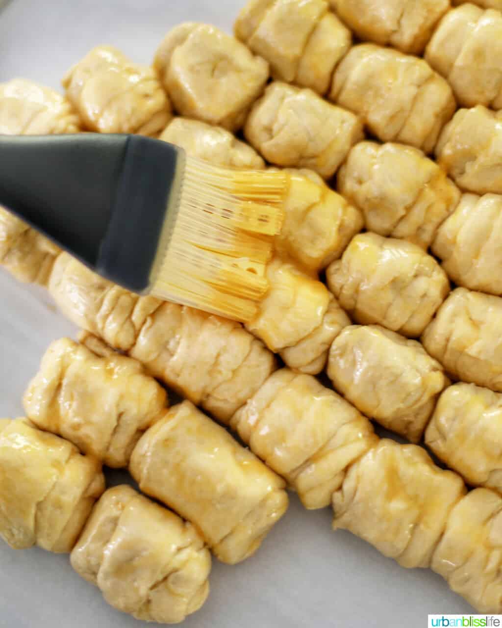 brushing egg wash onto dough