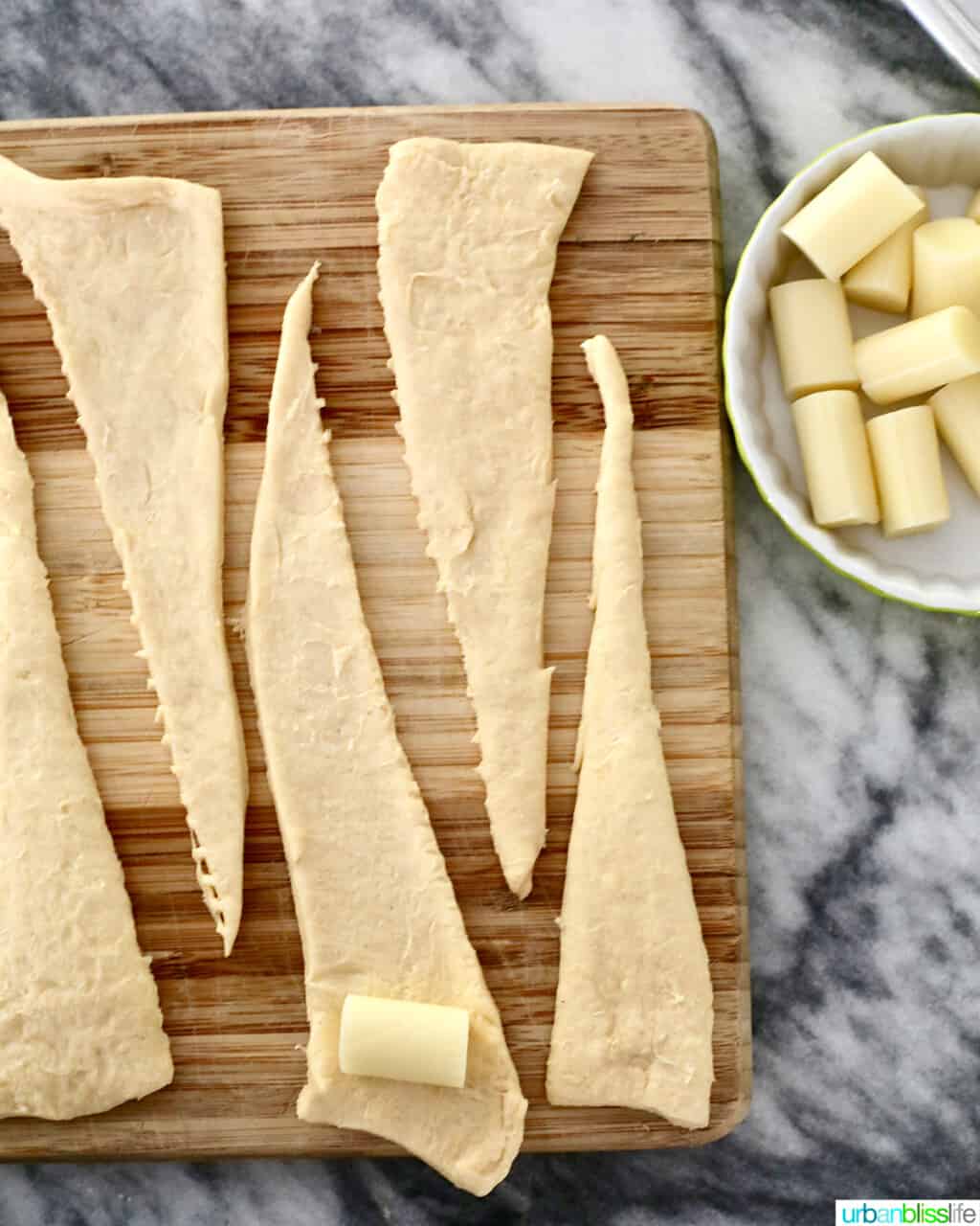 rolling mozzarella cheese inside dough