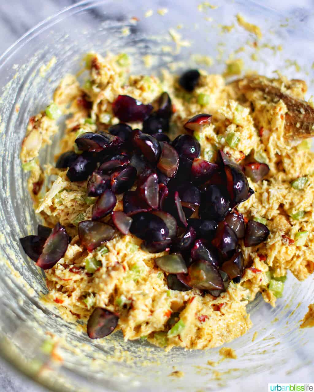 adding grapes to curry chicken salad