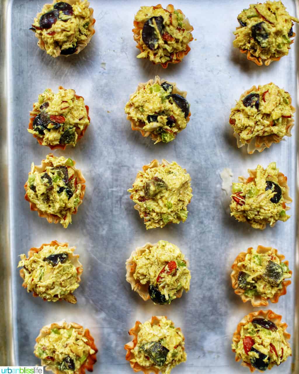 curry chicken salad phyllo dough appetizer bites on a baking sheet