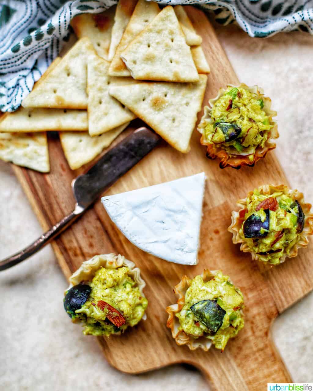 curry chicken salad on a cutting board with cheese and crackers