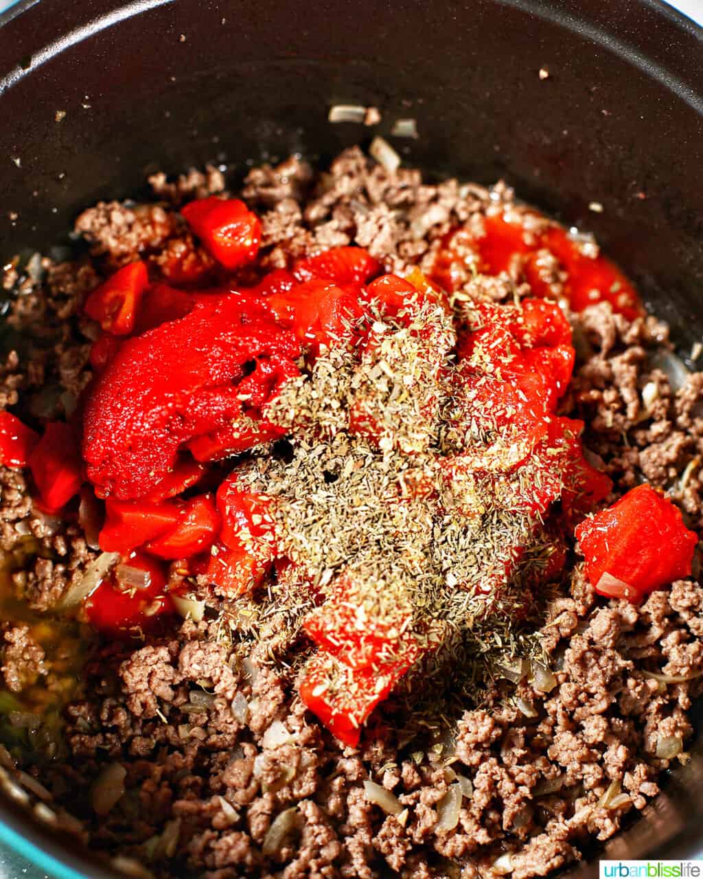adding tomato paste and herbs to ground beef