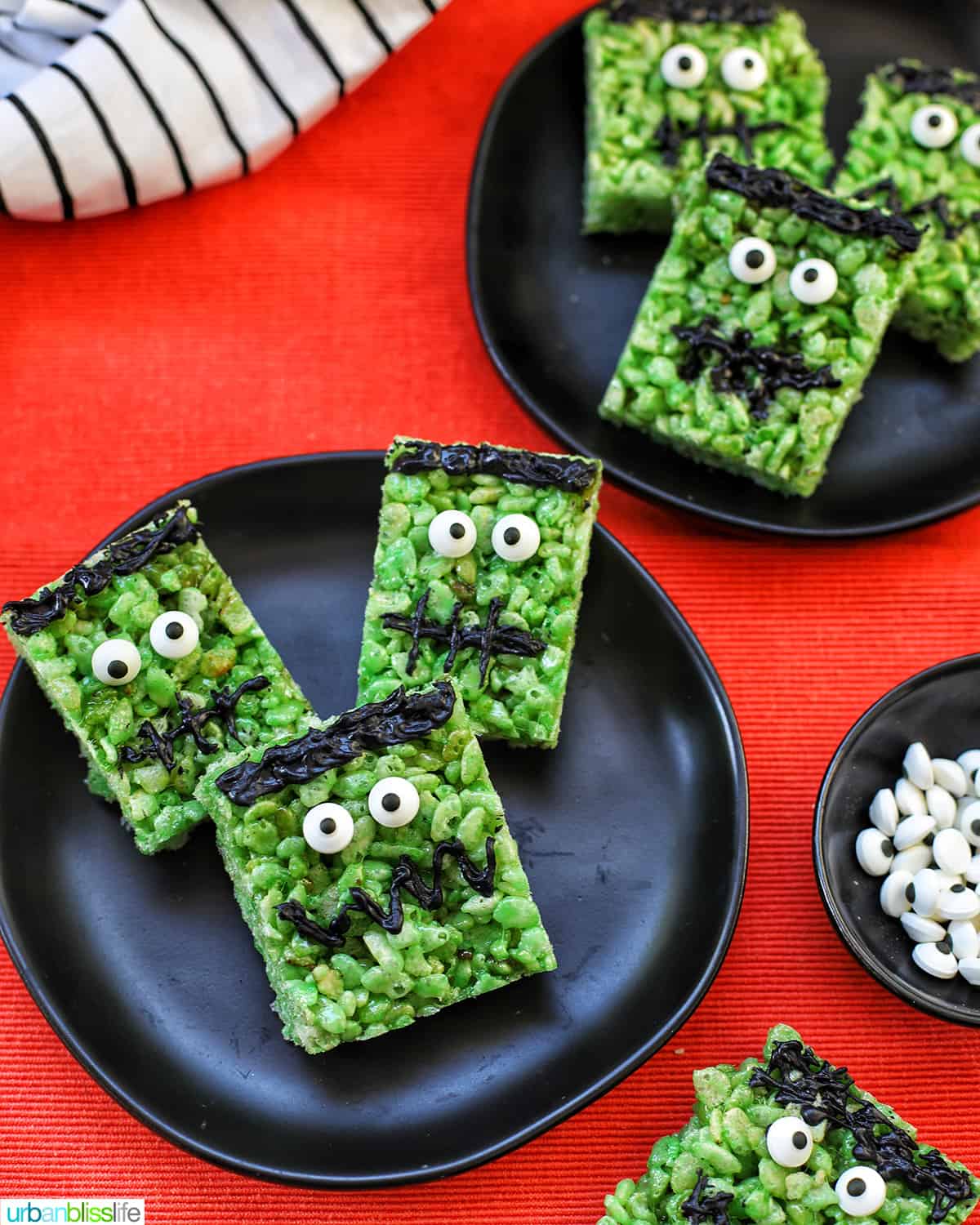 Frankenstein Rice Krispie Treats on top of black plates and orange background.