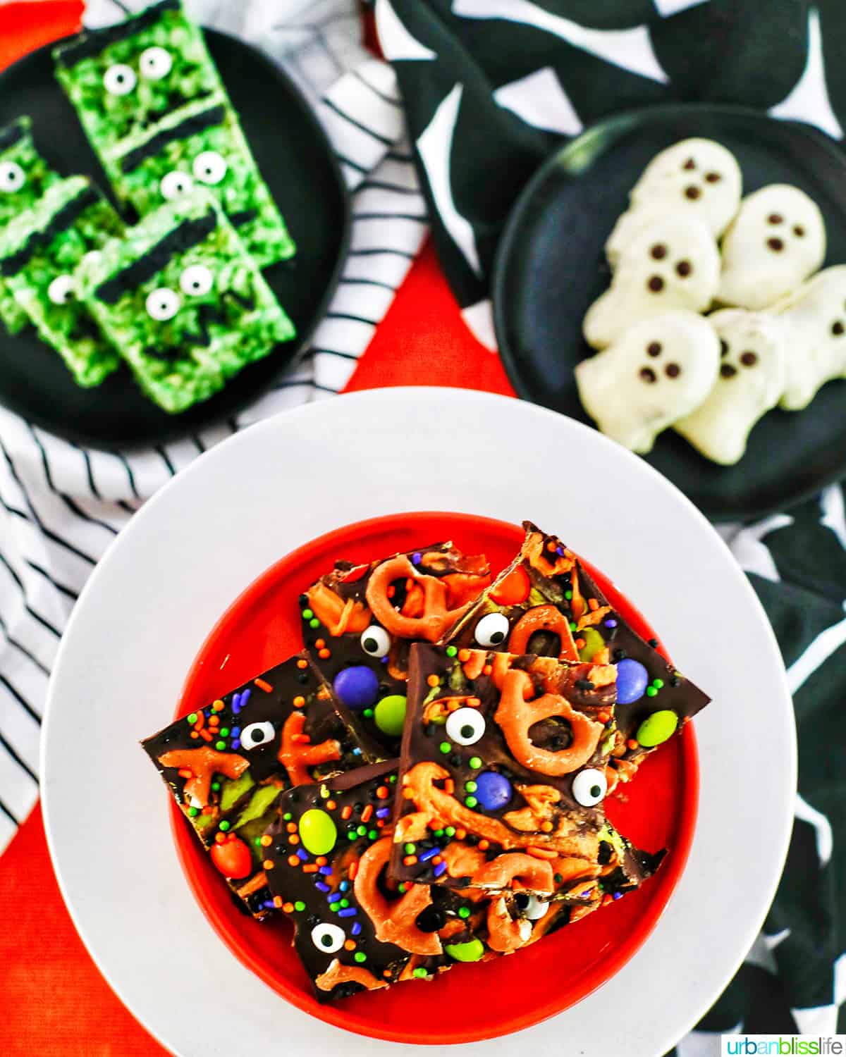 trio of Halloween treats on orange, black, and white plates with Halloween bark.