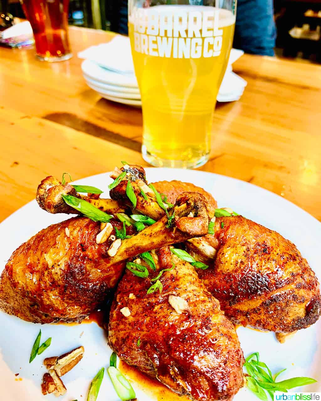 plate of chicken drumsticks with beer in the background.