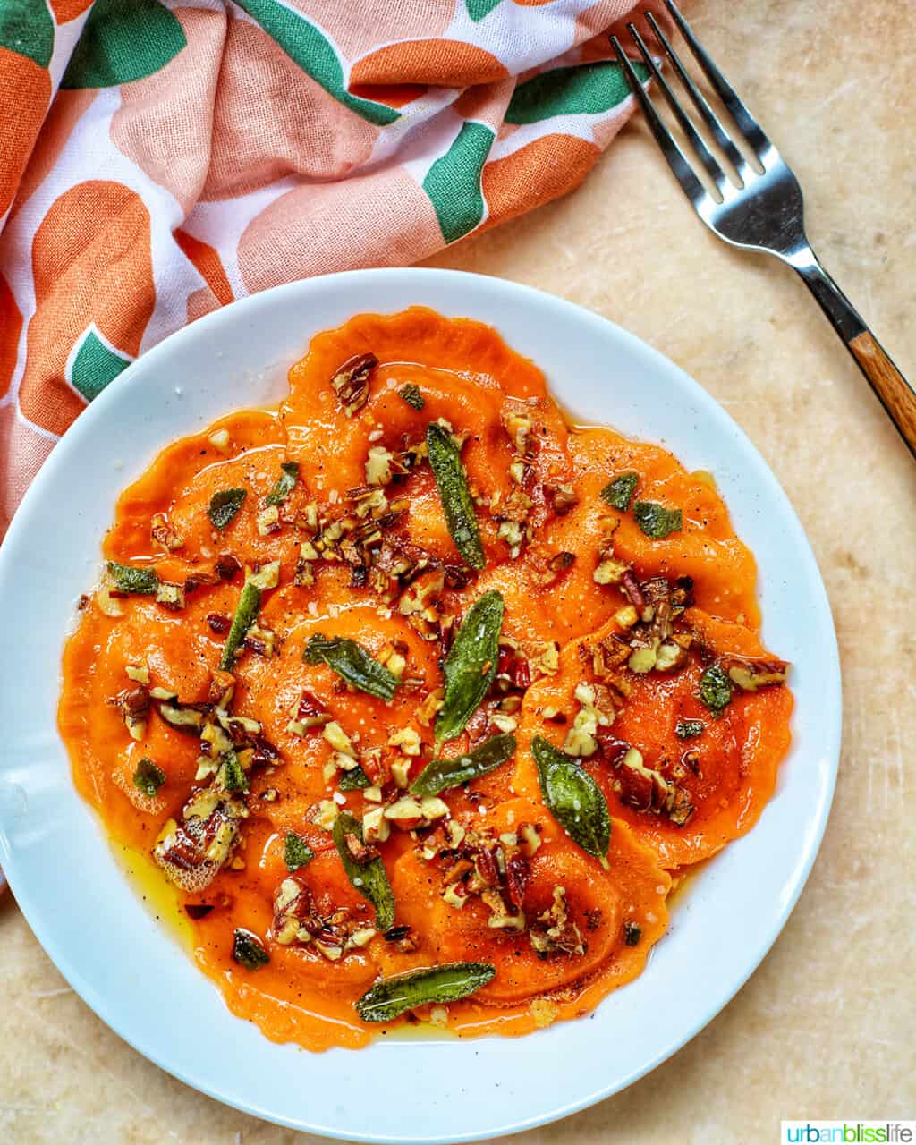 Butternut Squash Ravioli with Crispy Sage and Brown Butter Sauce in a white bowl with fork