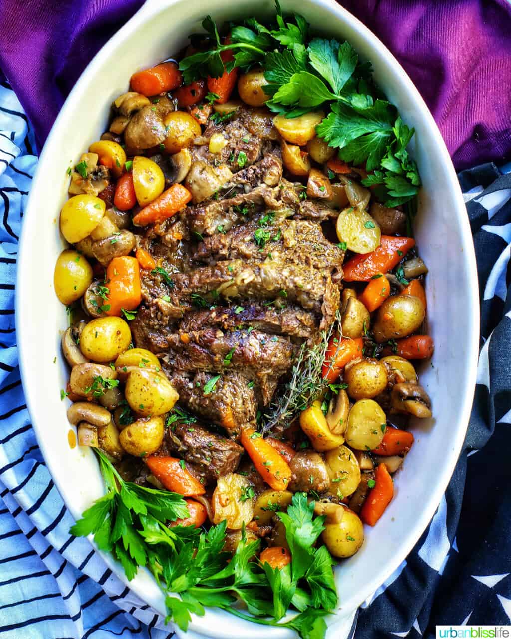 dutch oven pot roast with vegetables in a large white serving platter