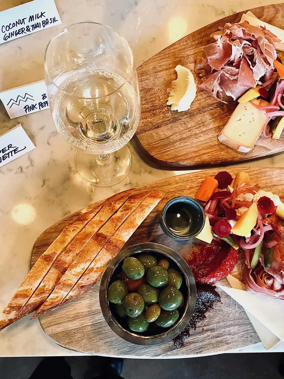 glass of white wine next to charcuterie boards  at normandie restaurant in Portland, Oregon.