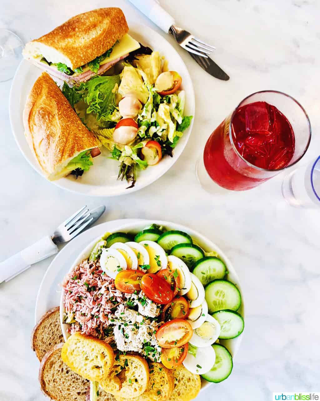 two plates with salads and sandwiches and a drink St Honore Boulangerie