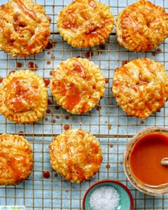 Air fryer apple hand pies on a rack with caramel