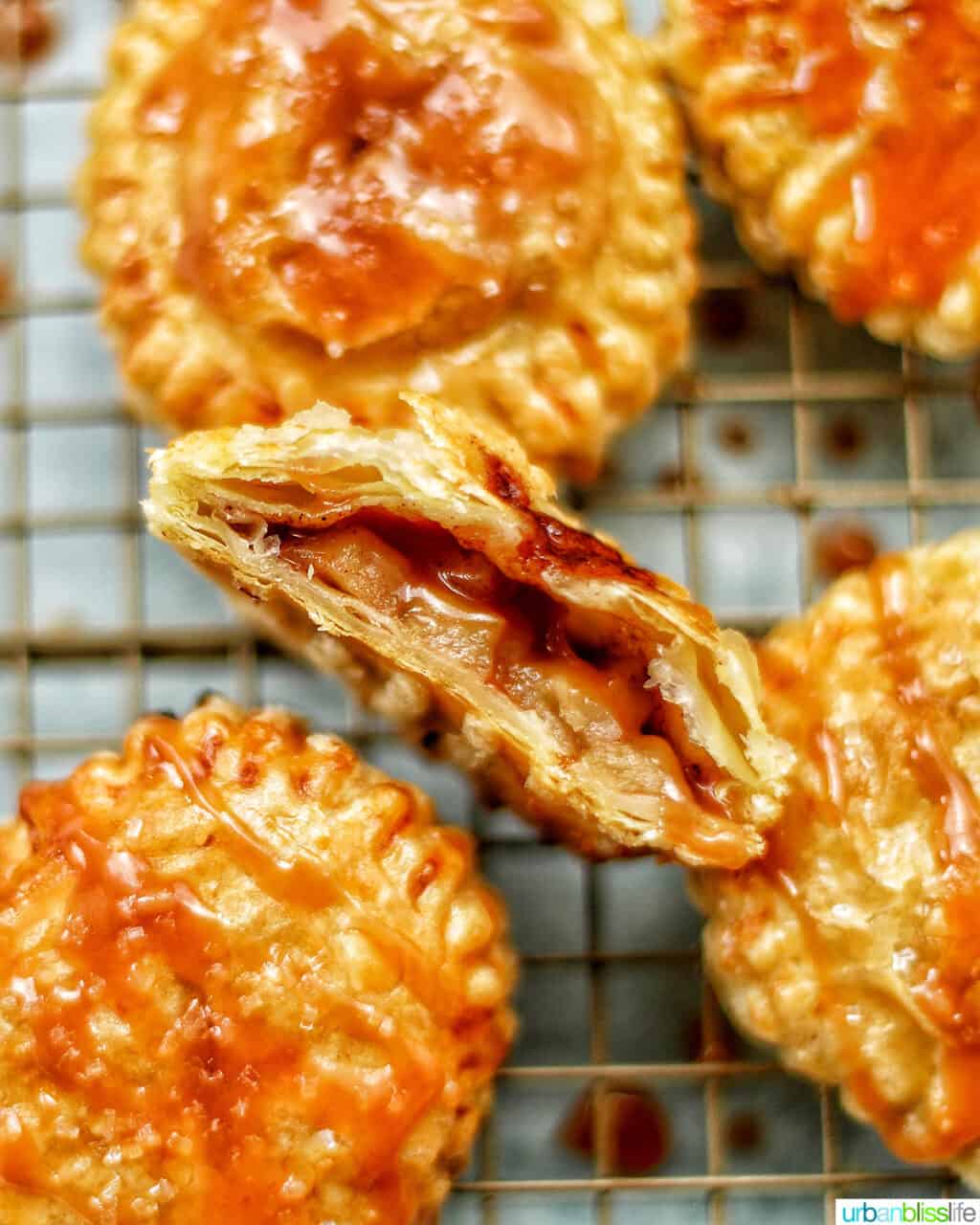 Air fryer apple hand pies with one cut open revealing apple pie filling