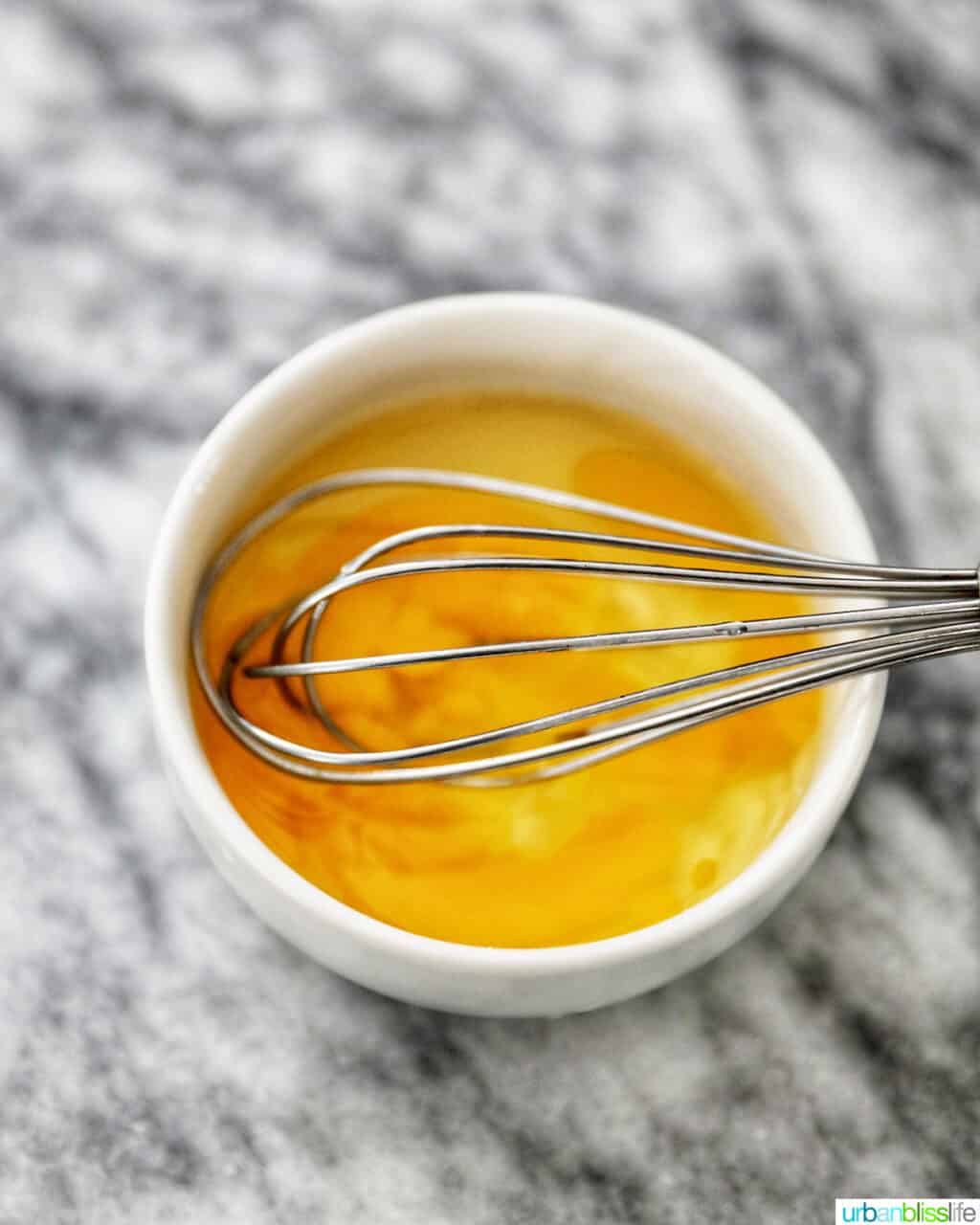 bowl of egg wash and whisk