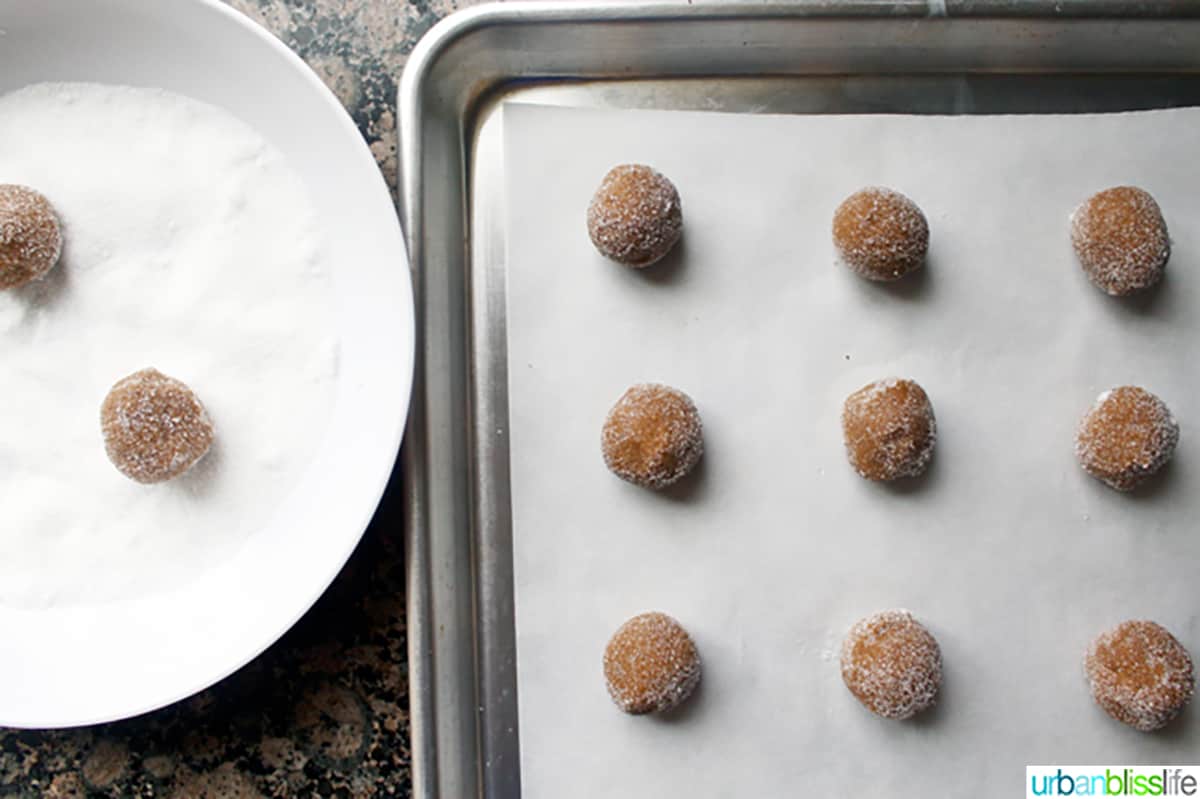 ginger molasses cookie dough balls on a baking sheet.