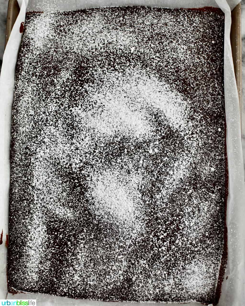 sprinkled powdered sugar over chocolate cake