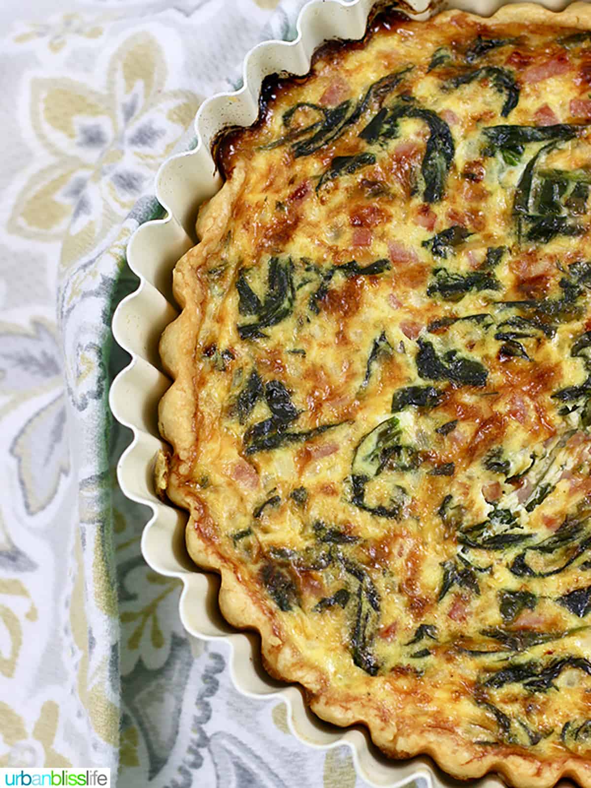 half of a ham cheddar and spinach quiche.
