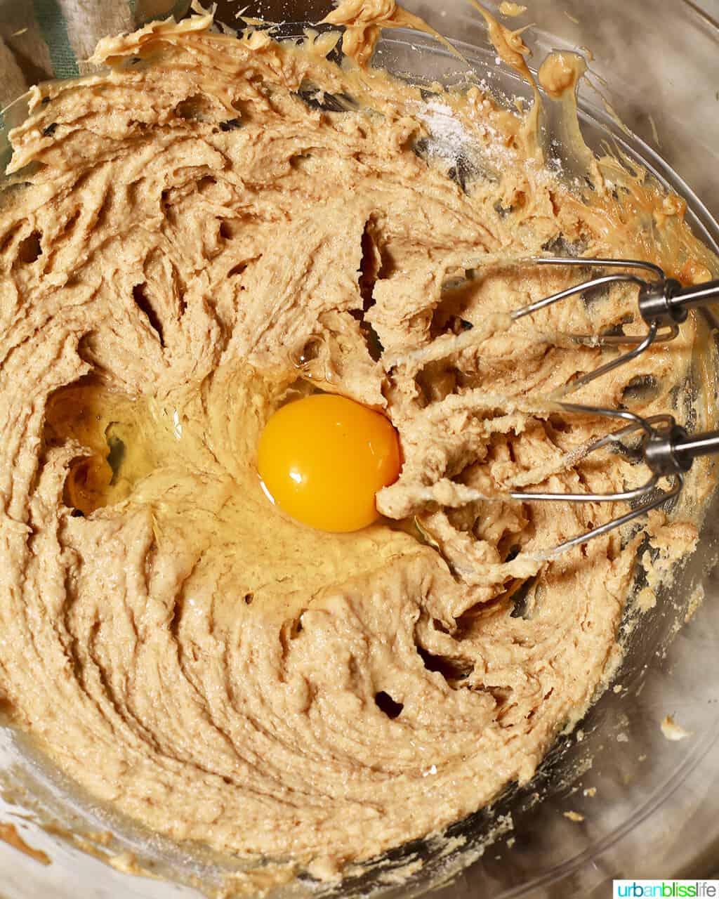 adding egg to cookie batter