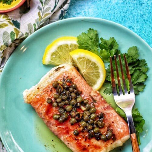 prosciutto wrapped halibut on a green plate