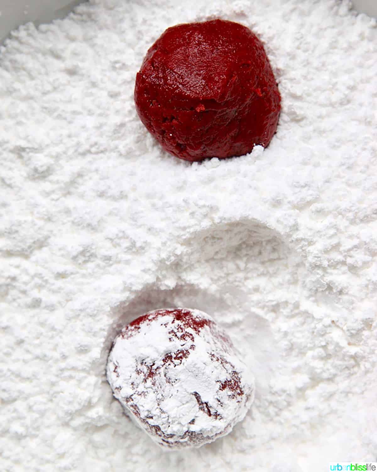 red velvet crinkle cookie dough ball in powdered sugar