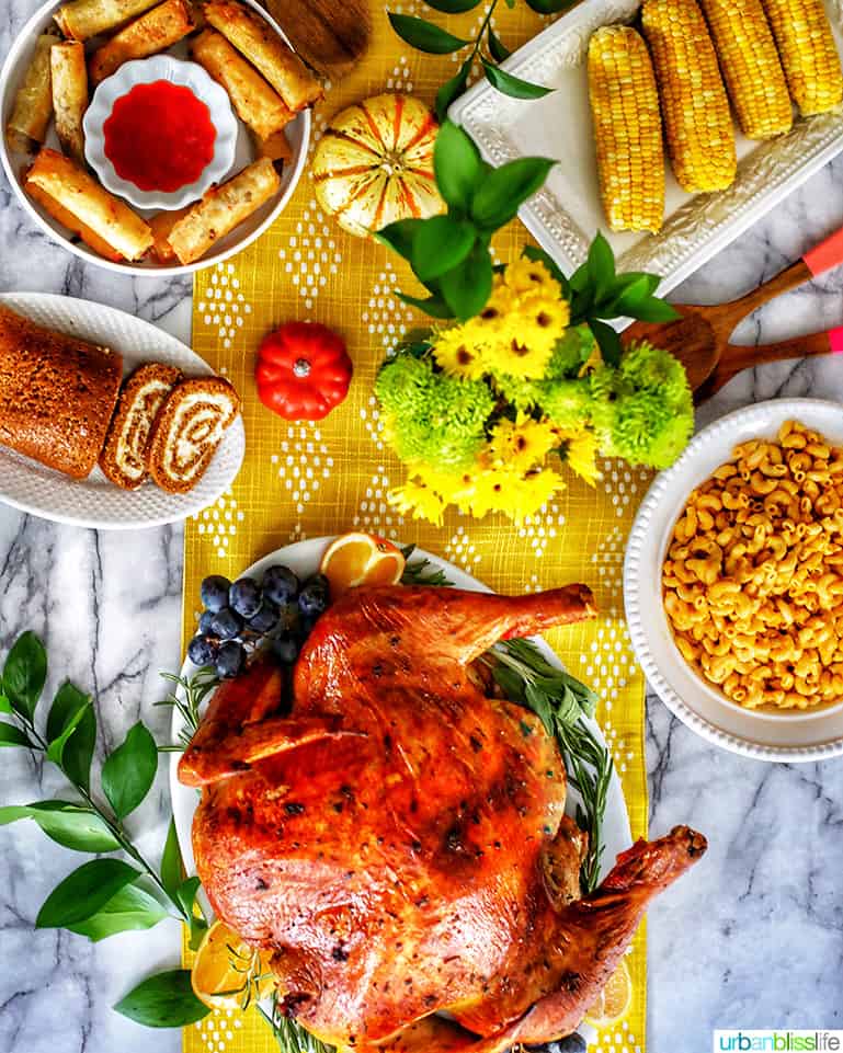Thanksgiving table with turkey, mac and cheese, mashed potatoes, pumpkin roll, corn on the cob