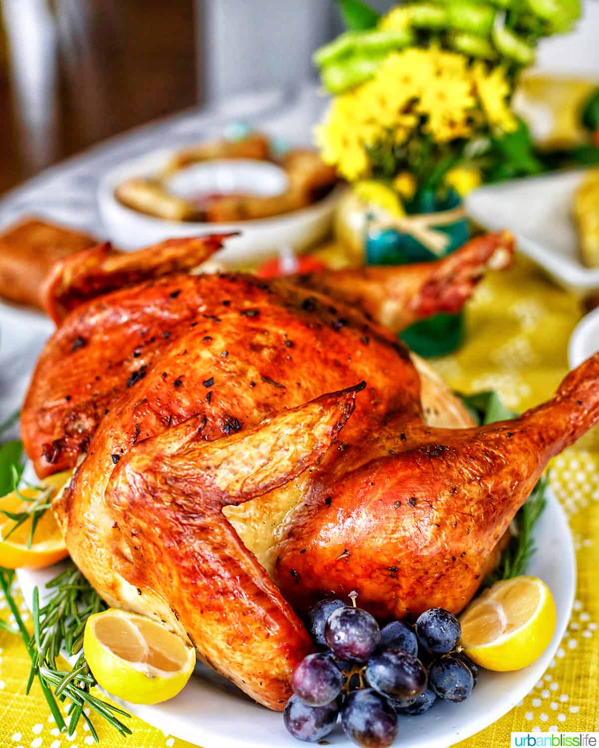 Thanksgiving turkey  with grapes, herbs, and lemons on a set Thanksgiving table.