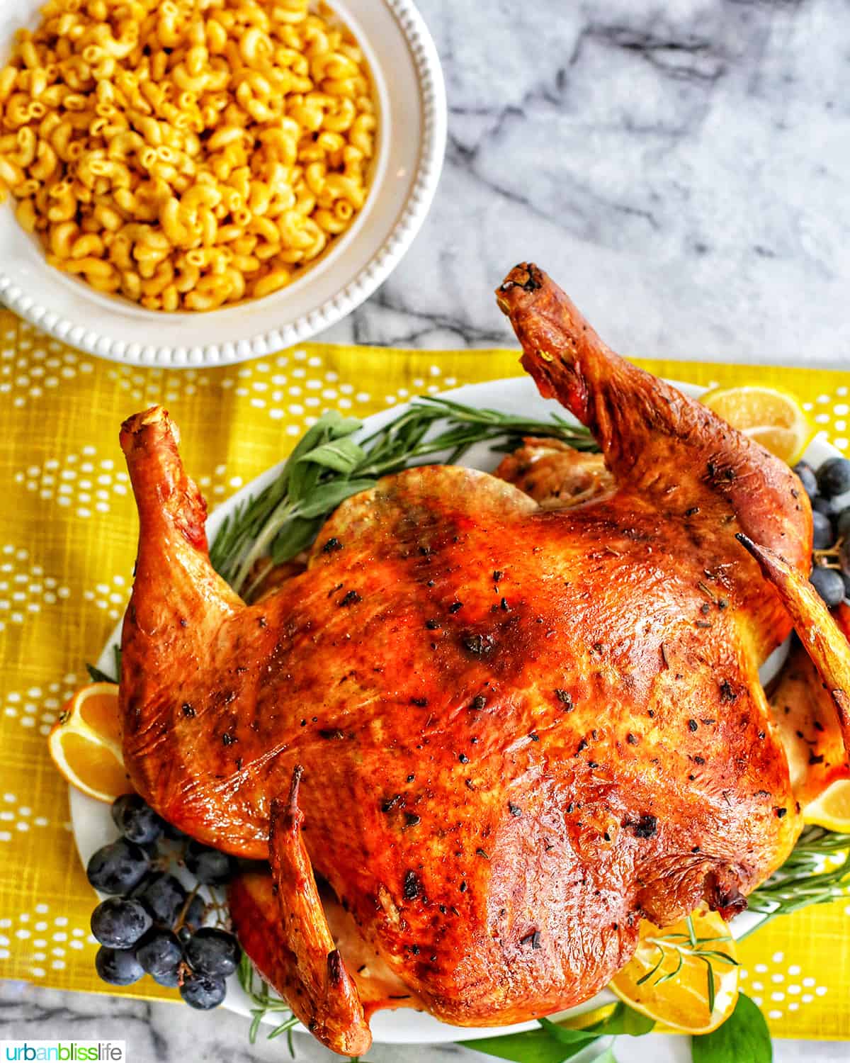 spatchcock turkey with herbs, grapes, and lemons, a side of mac and cheese for Thanksgiving.