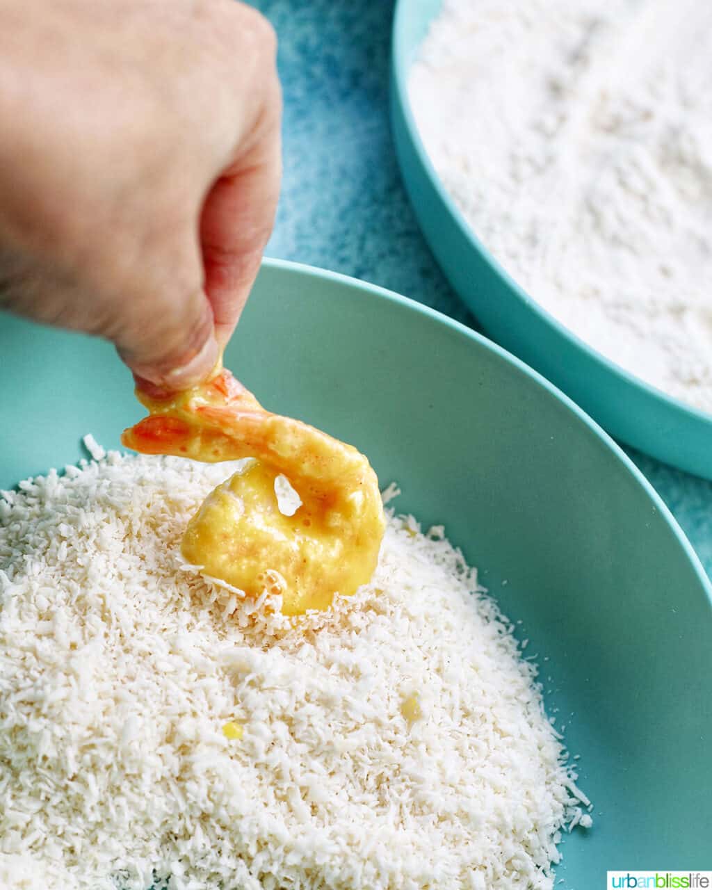 dredging shrimp in shredded coconut for coconut shrimp