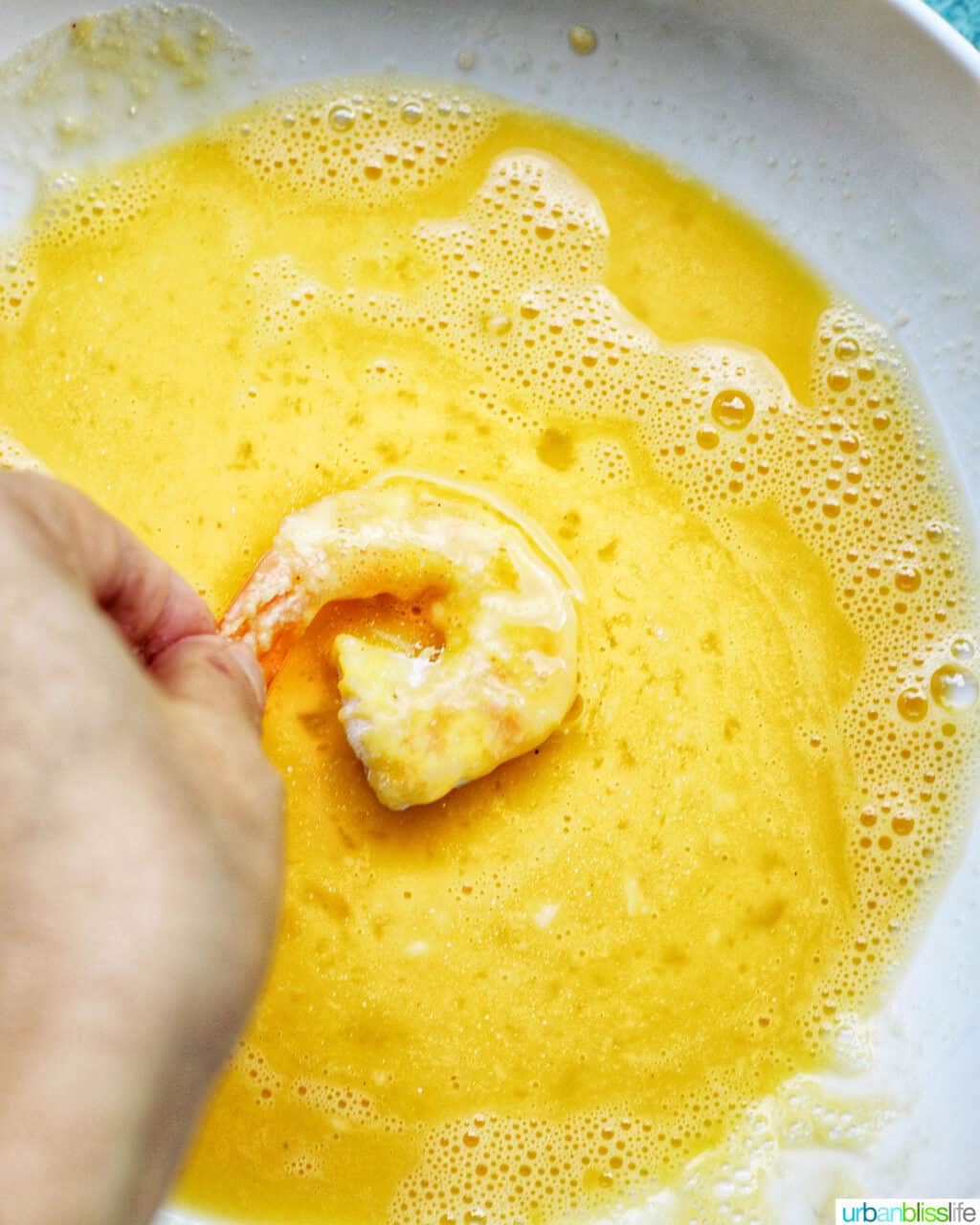 dredging shrimp in egg for coconut shrimp