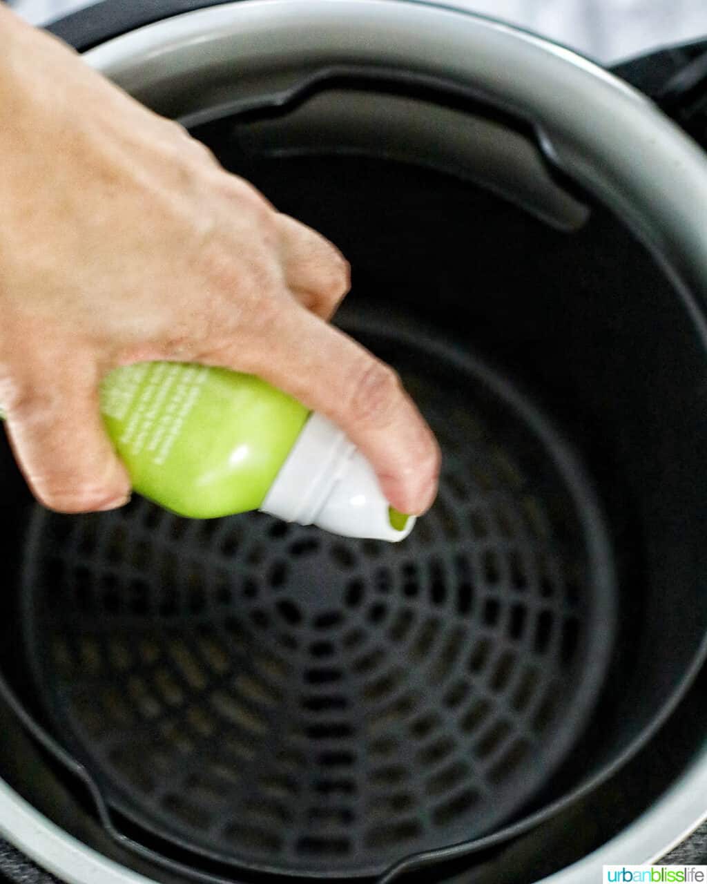 spraying avocado oil on air fryer