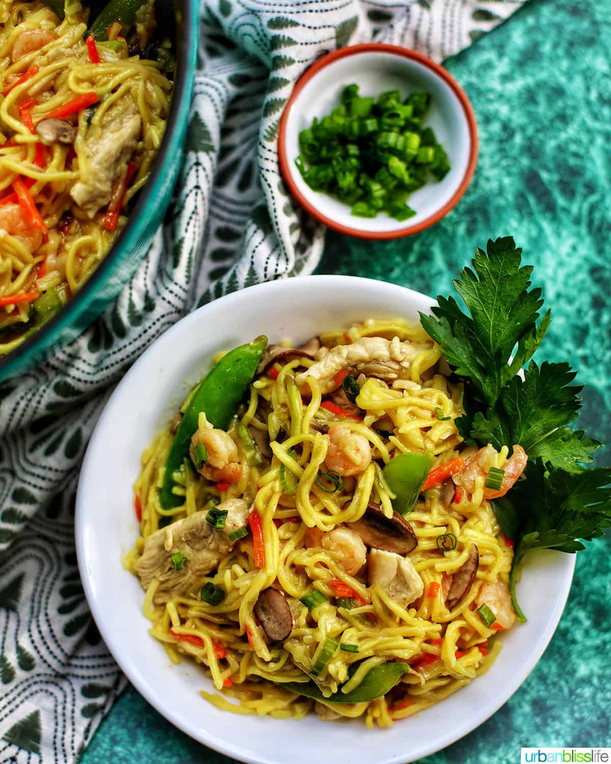bowl and pot of Filipino Pancit Canton Noodles with shrimp, chicken, and vegetables.