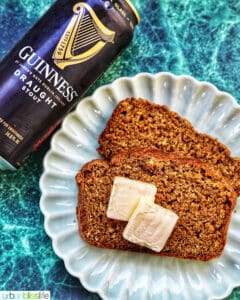 slices of Guinness brown bread with pats of butter and a Guinness beer