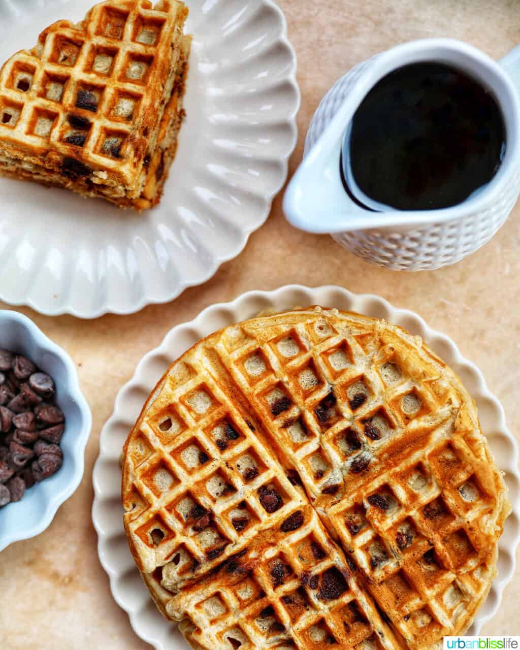 plate of full and sectioned banana chocolate chip waffles with syrup and chocolate chips