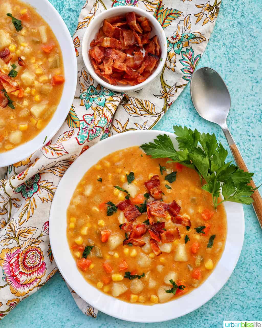 Two bowls of Instant Pot Potato Corn Chowder with side of bacon