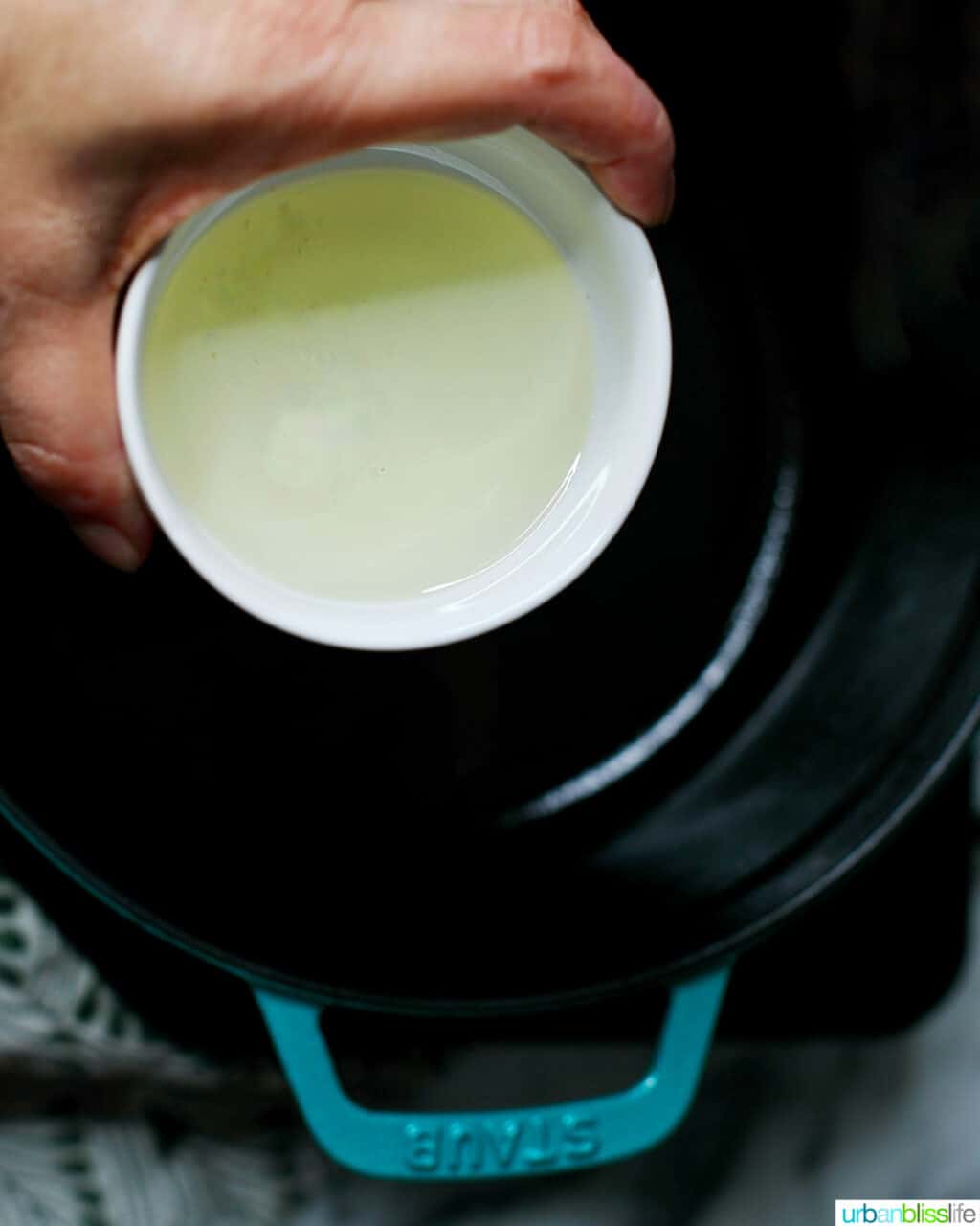 adding olive oil to pot