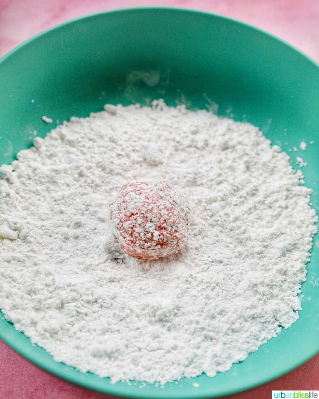 strawberry crinkle cookie dough ball rolled in powdered sugar