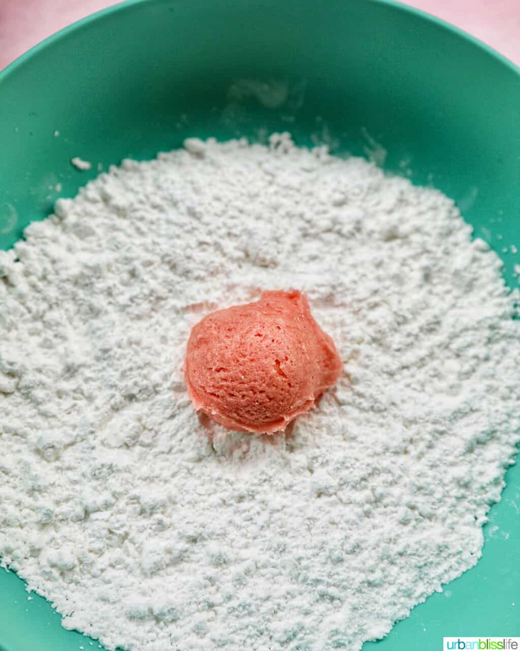 strawberry crinkle cookie dough ball rolled in powdered sugar
