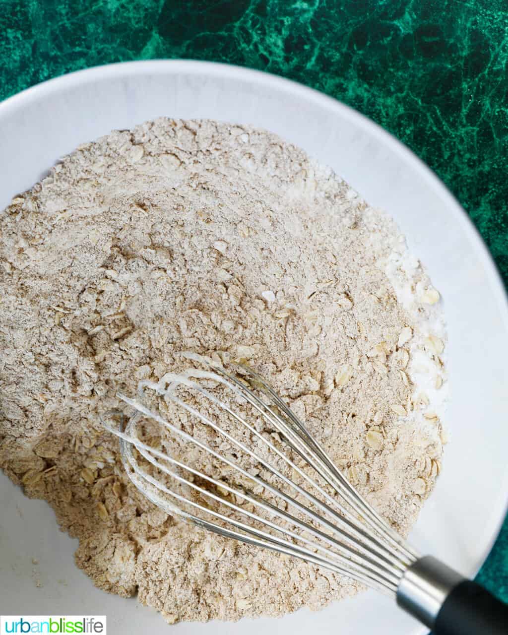 whisking dry bread batter ingredients in a bowl
