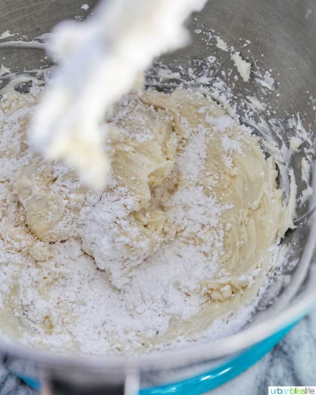 adding powdered sugar to the cream cheese frosting