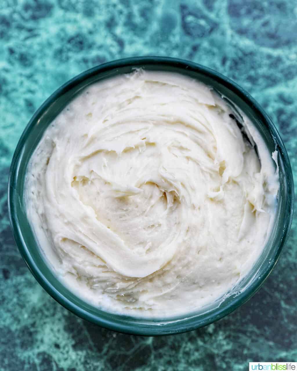 cream cheese frosting in a green bowl