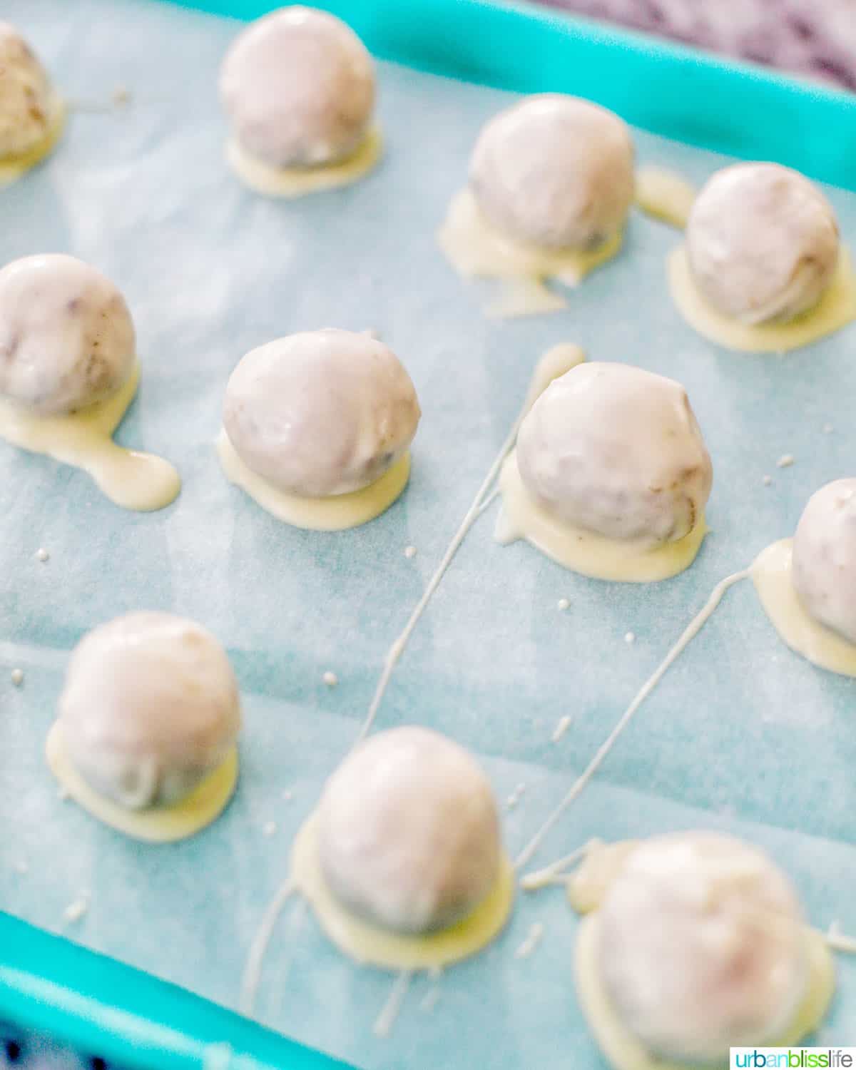 white chocolate coated truffles setting on baking sheet
