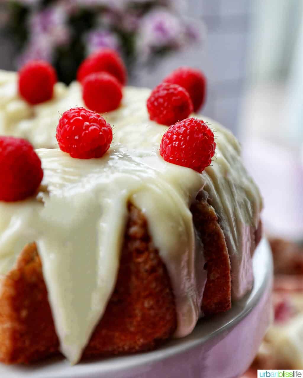 side view of white chocolate raspberry bundt cake with cream cheese frosting