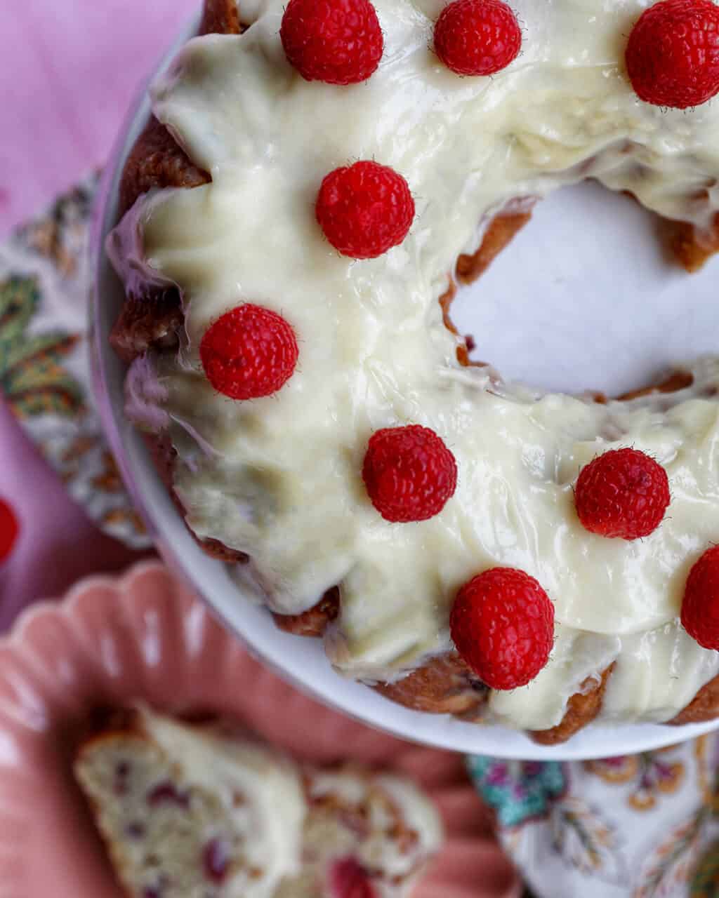 white chocolate raspberry bundt cake on pedestal