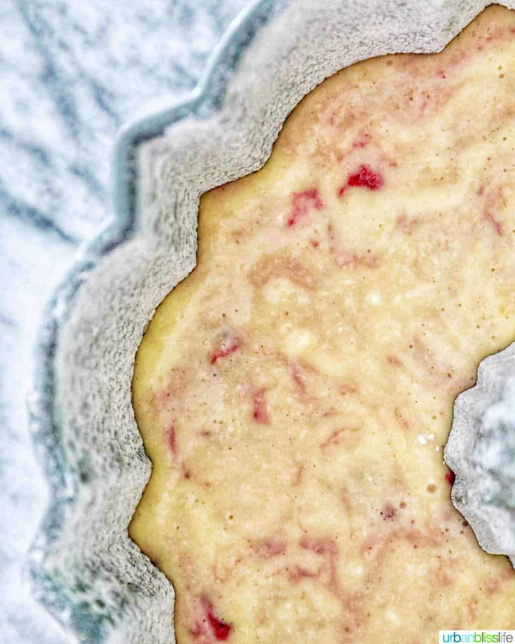 batter of white chocolate raspberry bundt cake poured into bundt cake pan