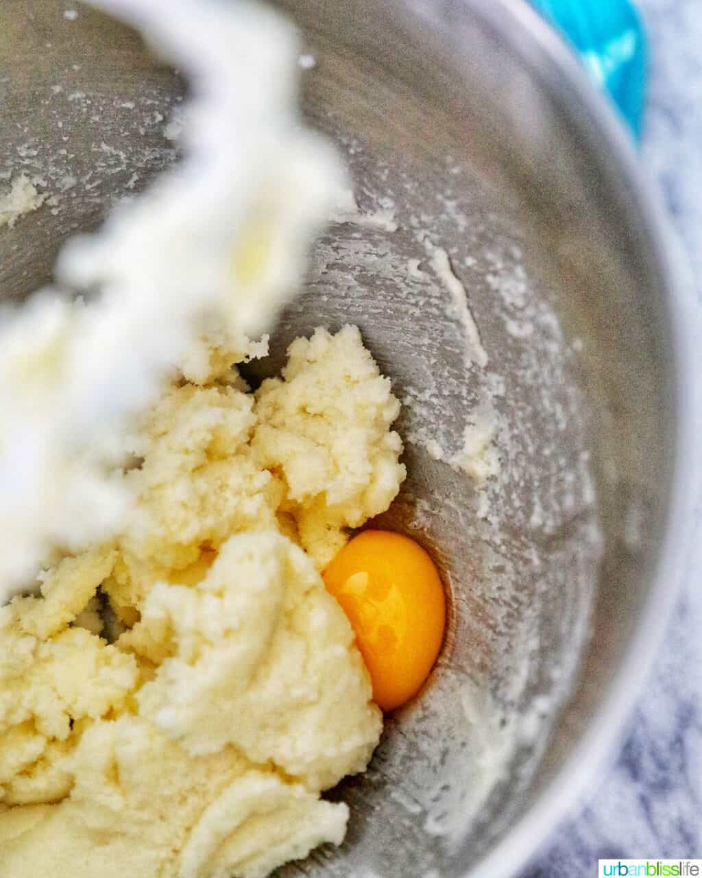 adding eggs to mixer