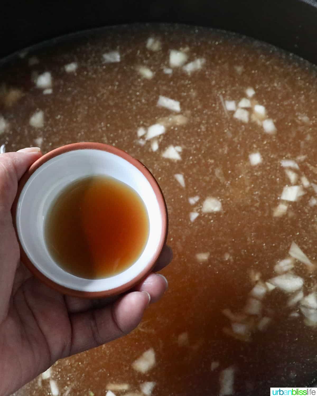 adding fish sauce to almondigas