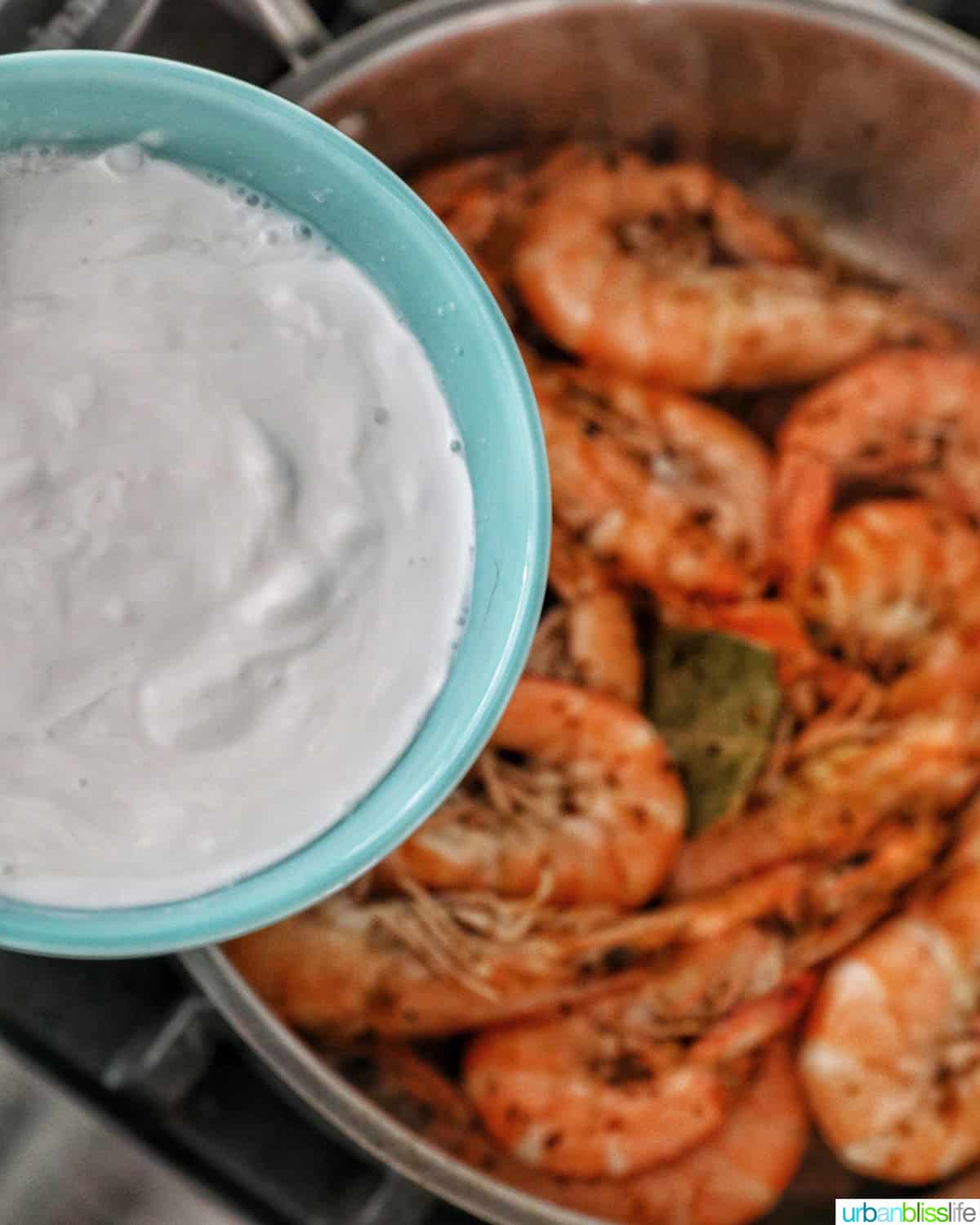 adding coconut milk to shrimp adobo