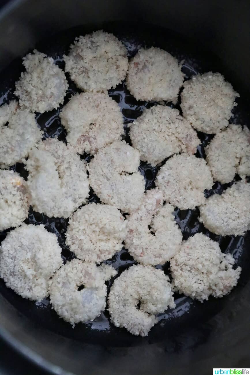 coated shrimp in the air fryer basket, ready to air fry