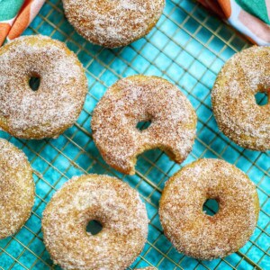 apple cinnamon donuts on a cooling rack.