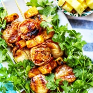 grilled bacon wrapped scallops on bed of lettuce.