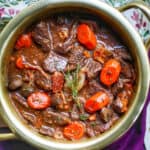 classic beef bourguignon in a gold colored bowl.